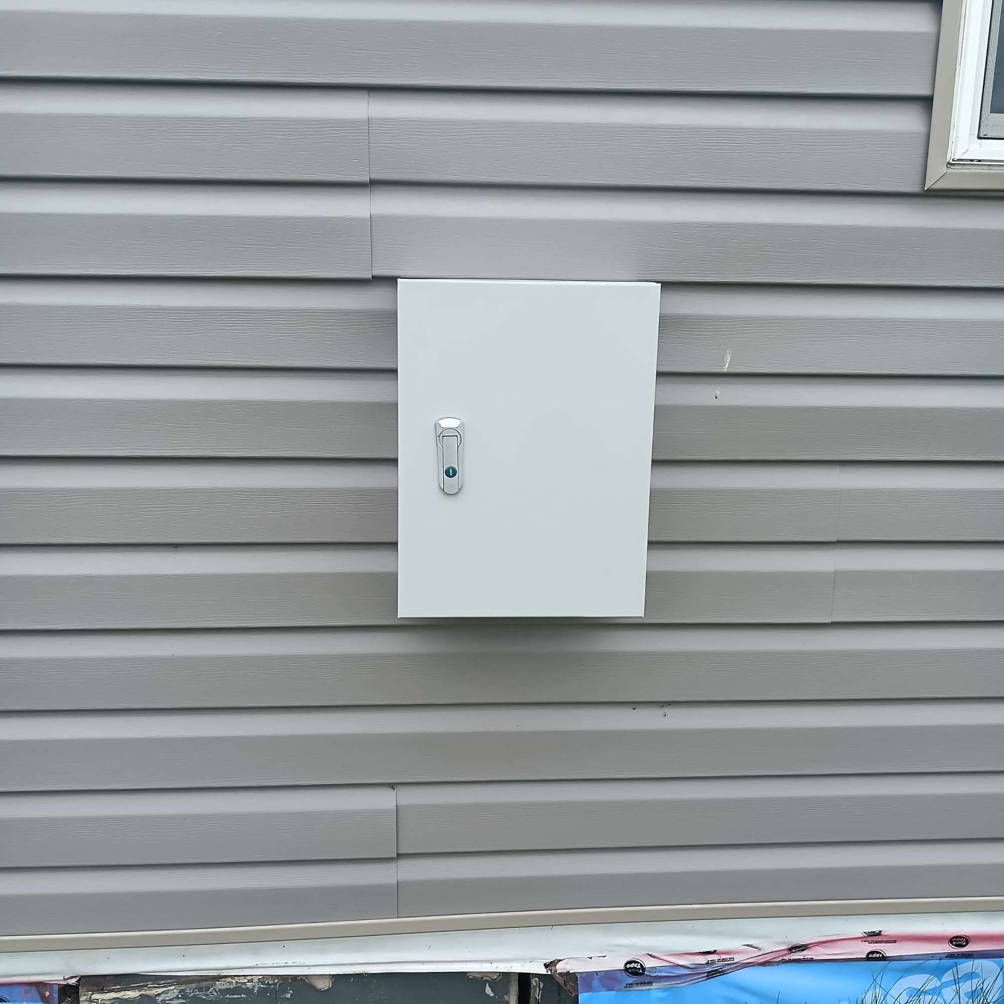 locked metal box mounted on a wall.